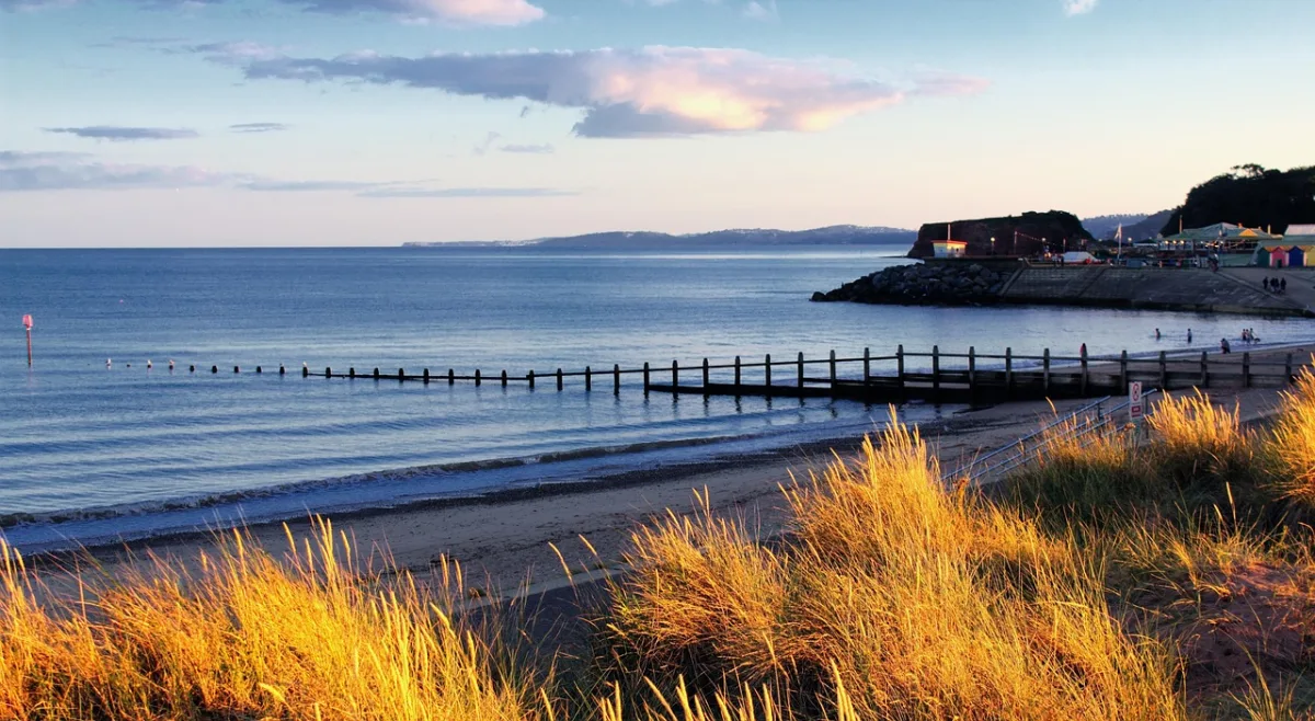 Picturesque UK coastal town harbour with colourful fishing boats at low tide